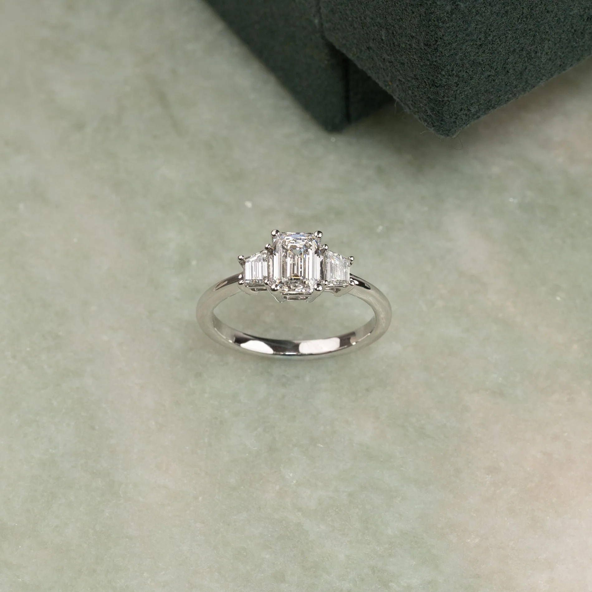 THREE-STONE EMERALD-CUT DIAMOND RING